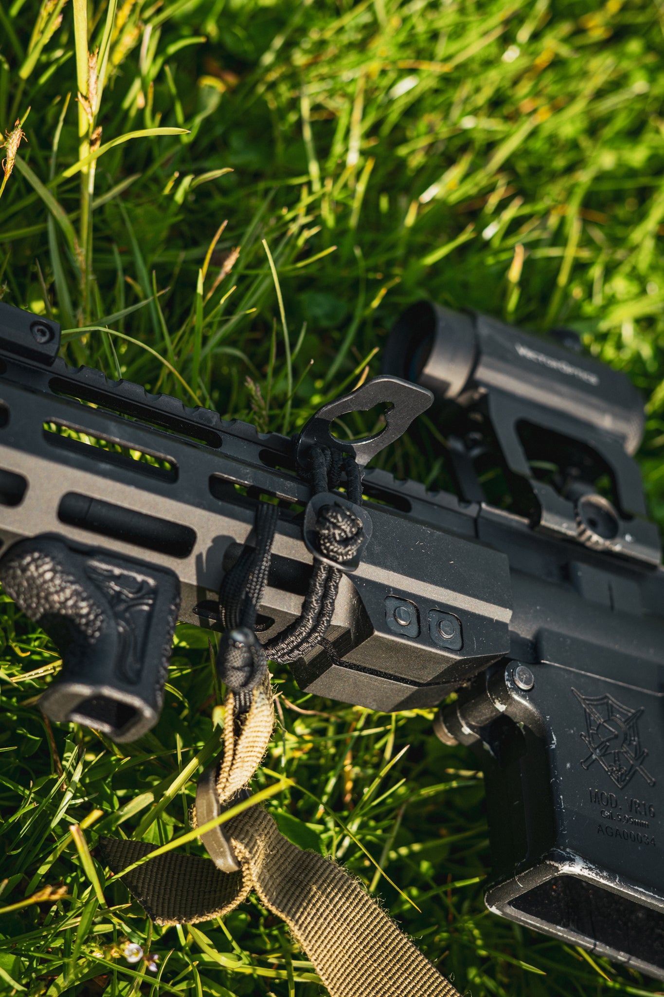 Black AR‑15 rifle with BUSS 2.0 on grass with a green background