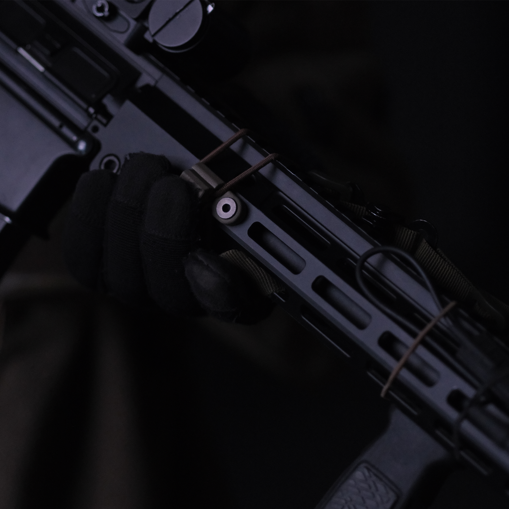 A black bungee cord sling system designed to be mounted on a M-LOK rail for stowing and deploying a sling.