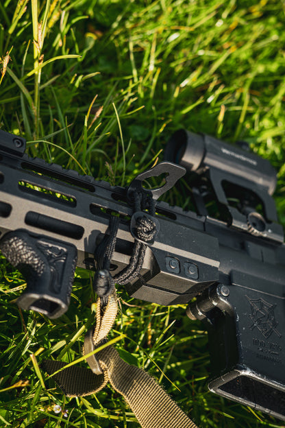 Black AR‑15 rifle  with BUSS 2.0 on grass with a green background


